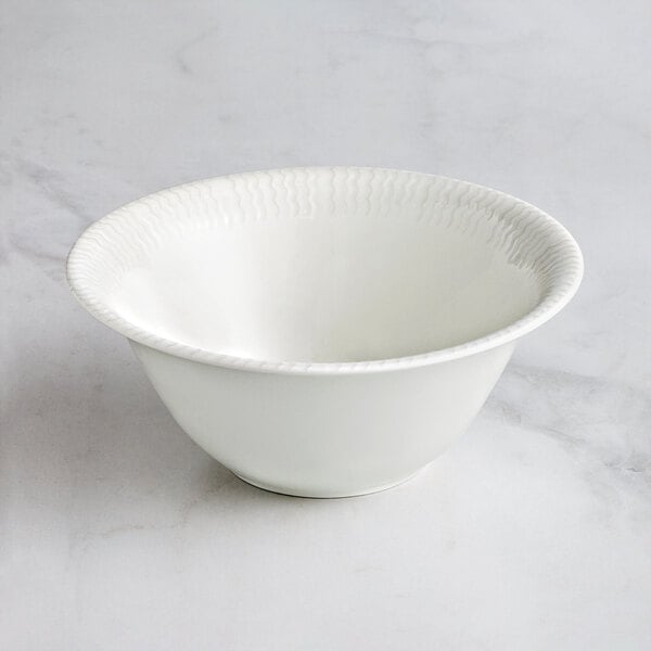 A RAK Porcelain Leon ivory porcelain bowl with wavy lines on the rim.