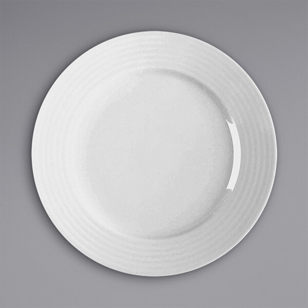 A white RAK Porcelain flat plate with a curved rim.