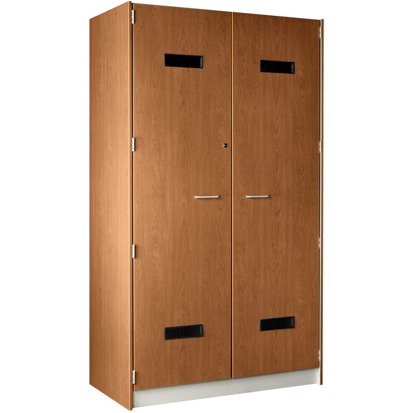 A medium cherry wooden locker with two doors and two drawers with silver handles.