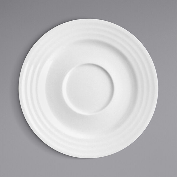 A white RAK Porcelain saucer with a circular embossed design.