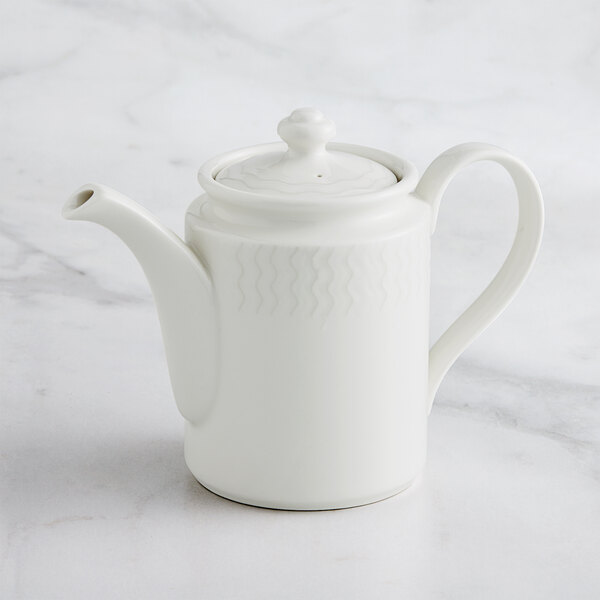 A RAK Porcelain Leon ivory porcelain coffee pot with a lid on a marble surface.