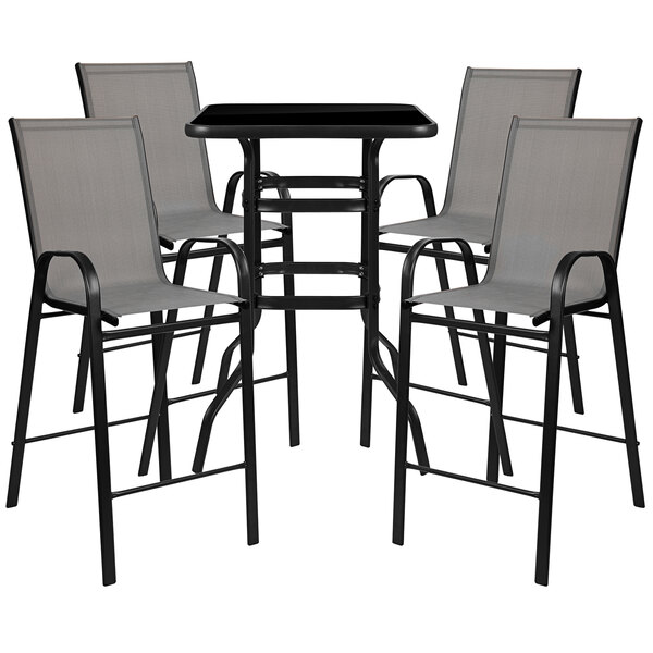 A Flash Furniture outdoor bar table with gray chairs on an outdoor patio.