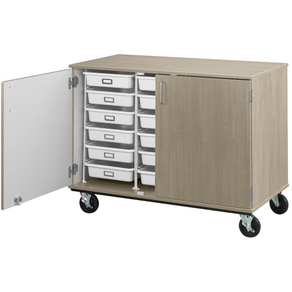 A natural elm I.D. Systems mobile storage cabinet with open drawers on wheels.