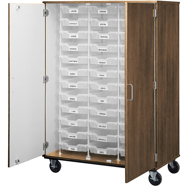 A tall dark walnut mobile storage cabinet with white bins on wheels.