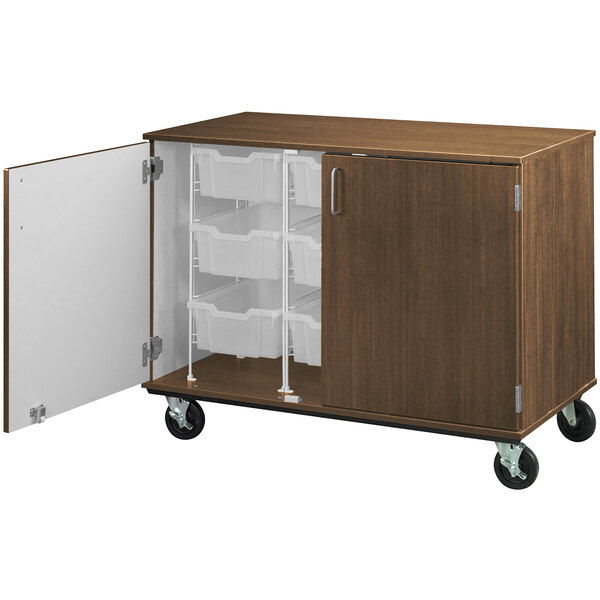 A dark brown mobile storage cabinet with white doors on wheels.