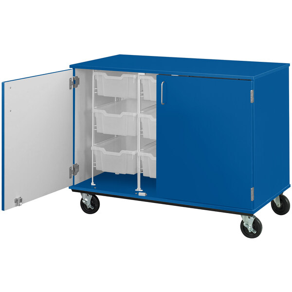 A blue I.D. Systems mobile storage cabinet with open bins on a shelf.