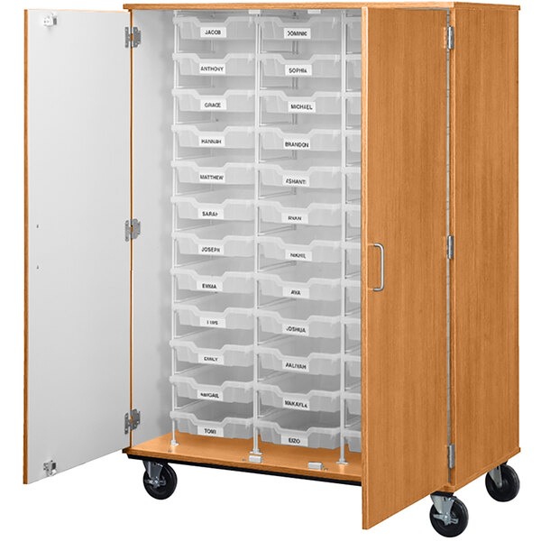 A tall light oak I.D. Systems mobile storage cabinet with drawers and bins inside.