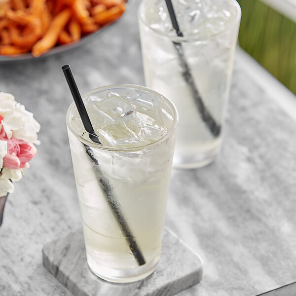 Two glasses of Pure Craft Homestyle Lemonade with straws on a marble surface.