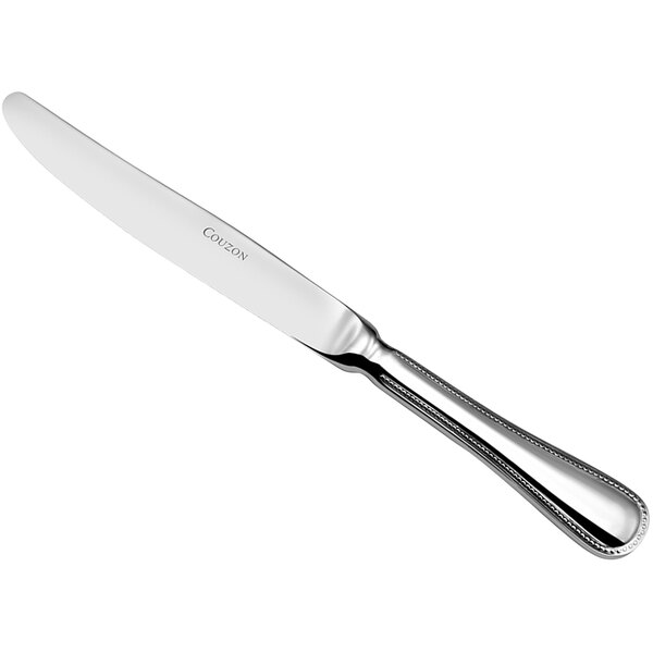 A silver Couzon by Amefa stainless steel dessert knife with a white handle.