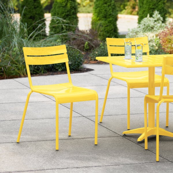 A yellow Lancaster Table & Seating outdoor chair on a patio.