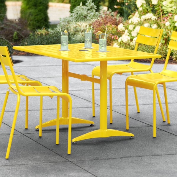 A yellow table and chairs on a patio.