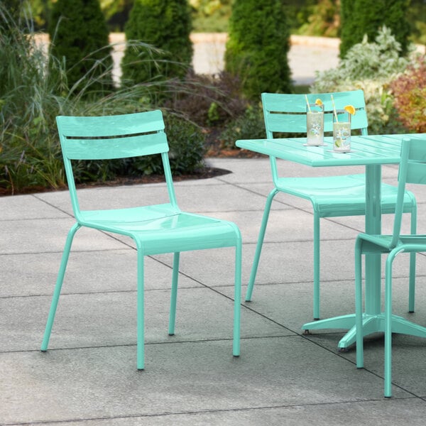 A Lancaster Table & Seating sea foam powder coated aluminum outdoor side chair on a patio.