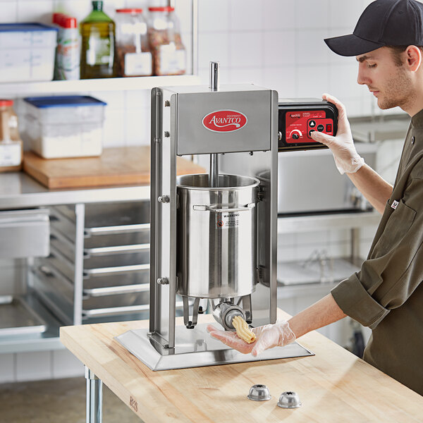 A man using a Avantco stainless steel Churro stuffer on a counter.
