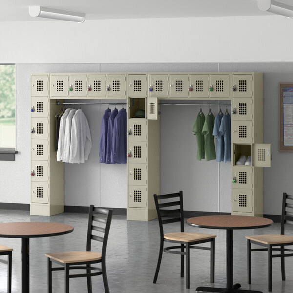A locker room with a Regency Space Solutions beige 6 tier locker with garment rack filled with shirts.