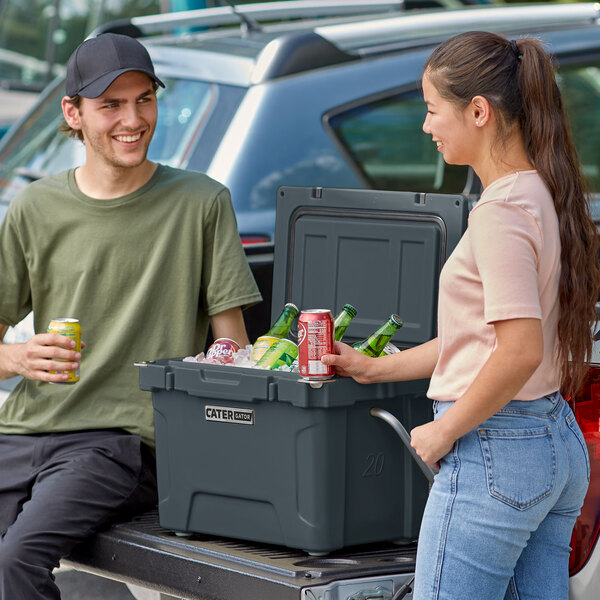 A man and woman standing next to a CaterGator outdoor cooler.