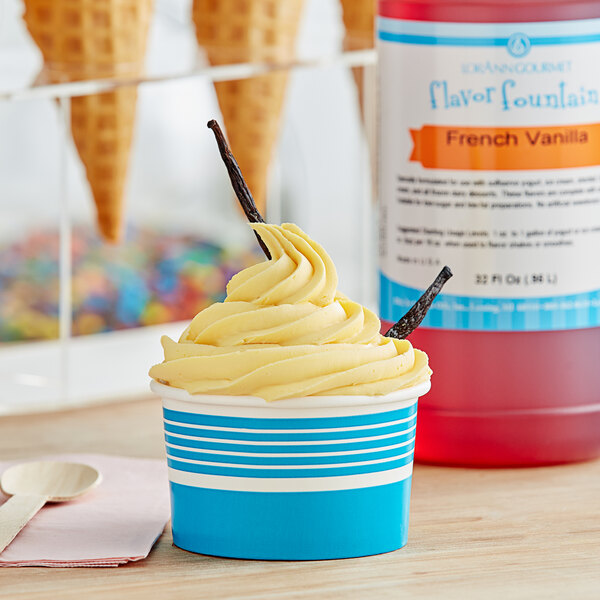 A cupcake with yellow frosting and a bottle of LorAnn French Vanilla Flavor syrup.