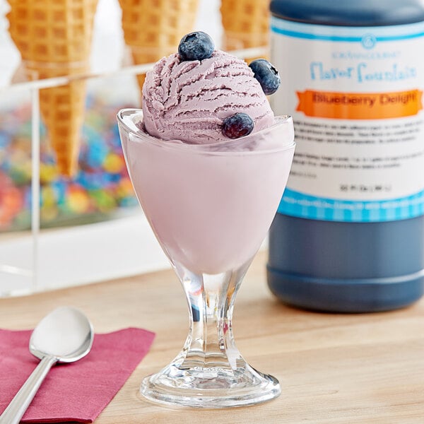 A scoop of LorAnn Blueberry Delight Flavor Fountain Syrup on a scoop of ice cream with blueberries.