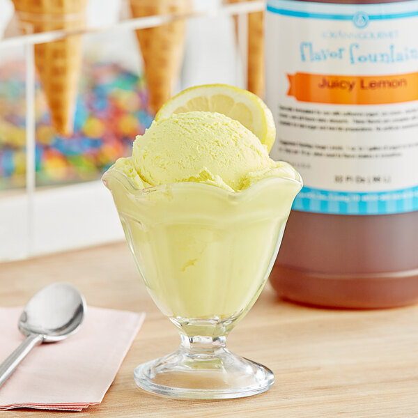 A glass of yellow ice cream flavored with LorAnn Juicy Lemon syrup with a spoon.