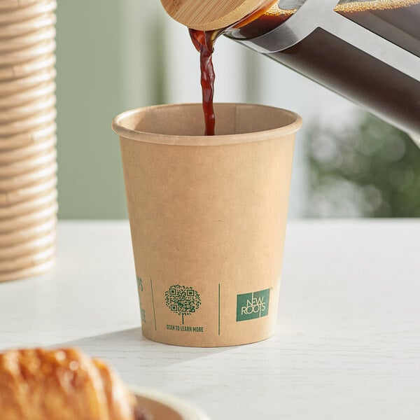 A brown New Roots paper hot cup being filled with coffee.