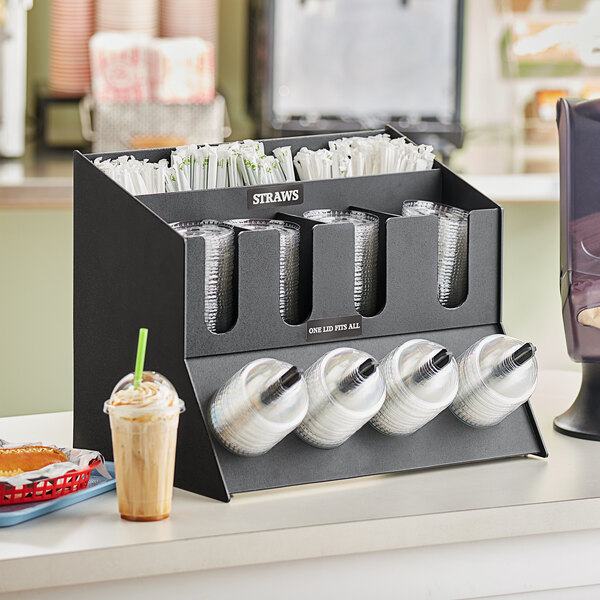A ServSense black plastic countertop organizer with sections for straws and lids.