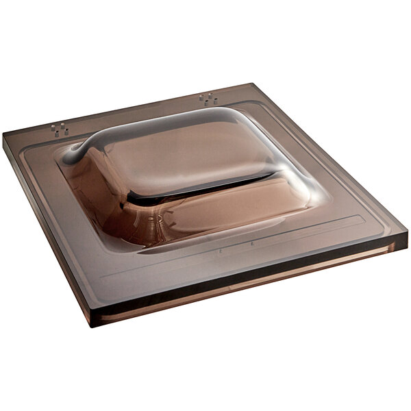 A brown square lid with a square object in the middle.