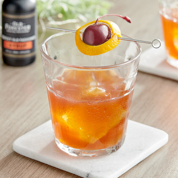 A glass of Old Forester Old Fashioned Syrup with a cherry and ice.