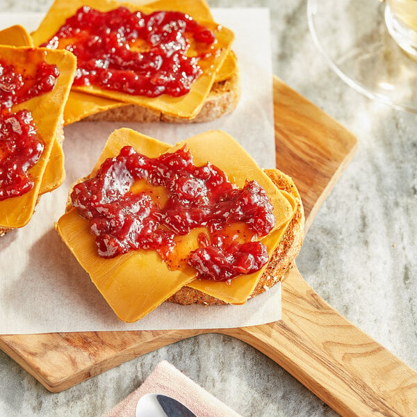 Two slices of Norwegian Gjetost cheese on bread with jam.