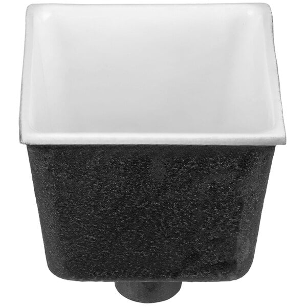A black and white square cast iron floor sink with a black and white label.