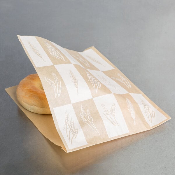 A bagel in a Bagcraft Packaging paper bag on a table.