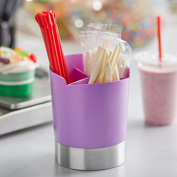 A purple cylinder with straws and utensils in it.