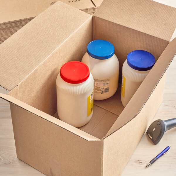 A Lavex kraft corrugated shipping box filled with white containers with blue lids.