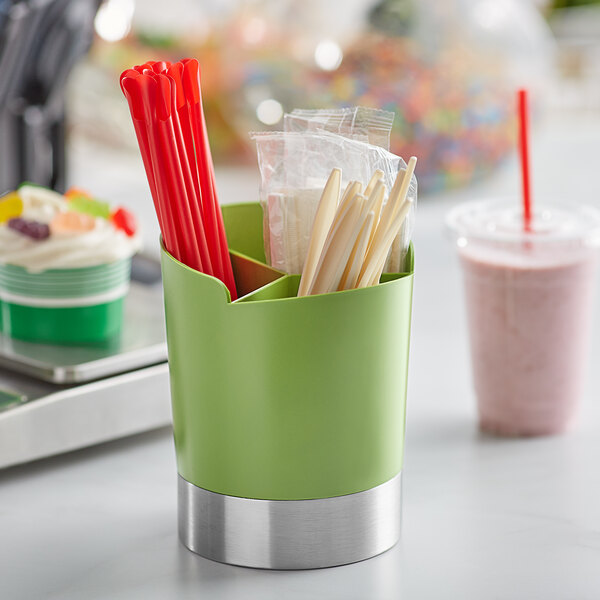 A green cylinder utensil holder on a counter.