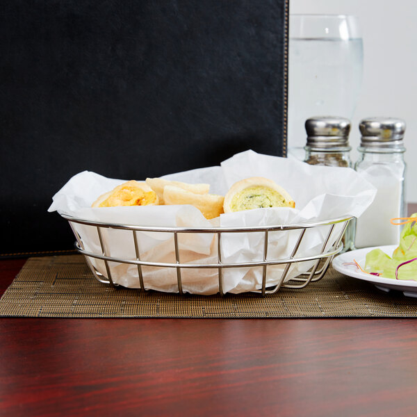 An American Metalcraft stainless steel wire basket on a table with food.