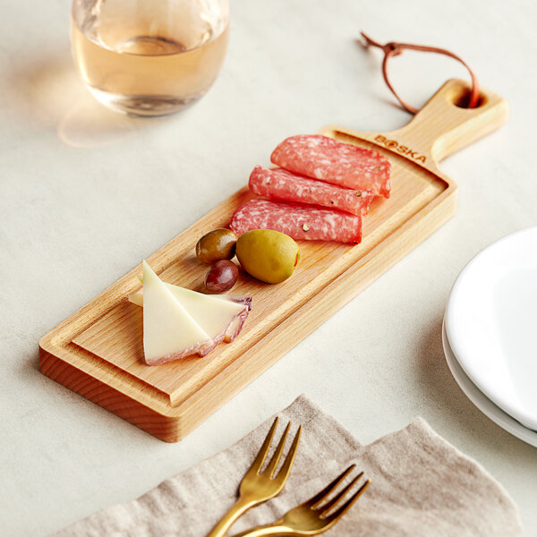 A Boska beech wood serving board with meat, olives, and cheese on it.