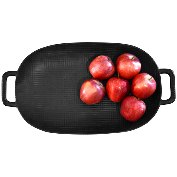 A group of red apples on a black Cal-Mil oval tray with handles.