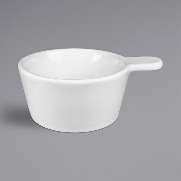 A close up of a white International Tableware porcelain sampling bowl with a handle.