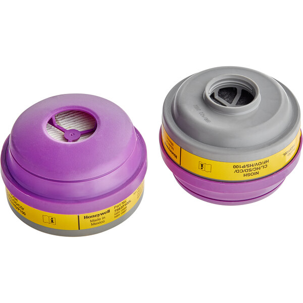 Two grey and purple Honeywell air filters with yellow caps.