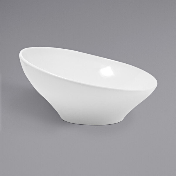 A Front of the House white porcelain slanted bowl on a gray background.