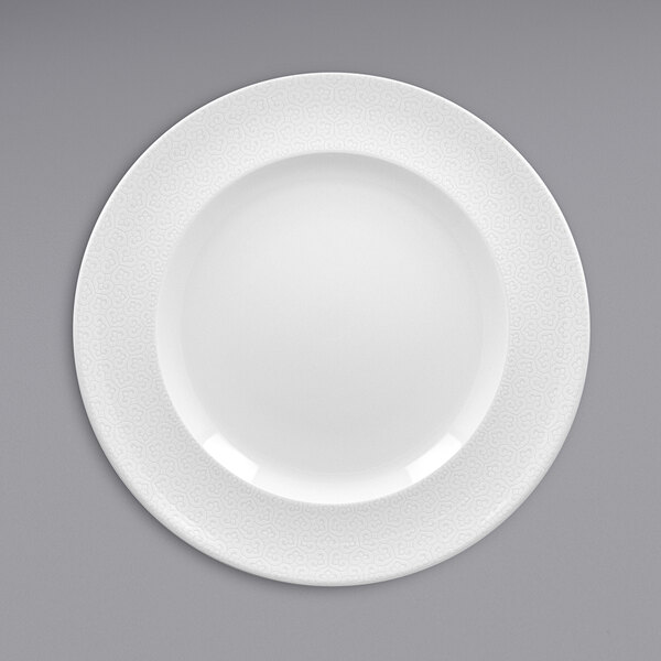 A white RAK Porcelain flat plate with an embossed rim.