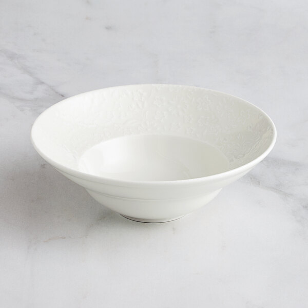 A RAK Porcelain ivory porcelain deep plate with a floral design on a white surface.