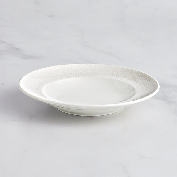 A RAK Porcelain ivory porcelain deep plate with an embossed rim.
