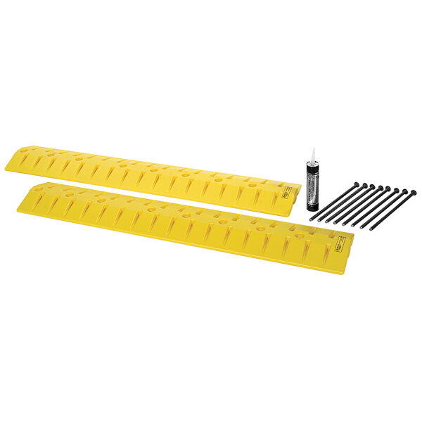 A close-up of a yellow plastic speed bump cable protector with black screws.
