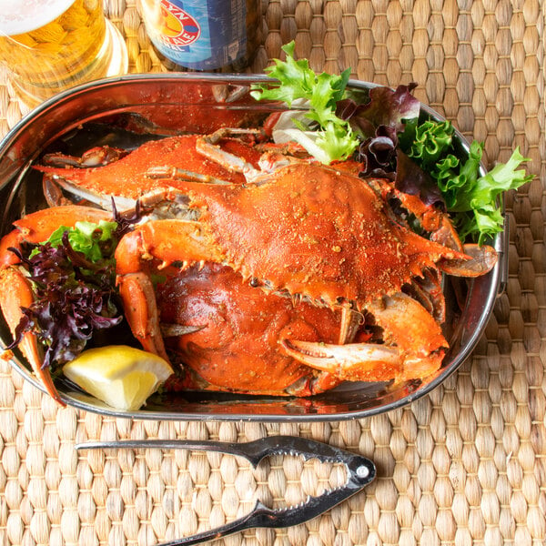 A bowl of lightly seasoned steamed Chesapeake blue crab with lemon and lettuce on the side.