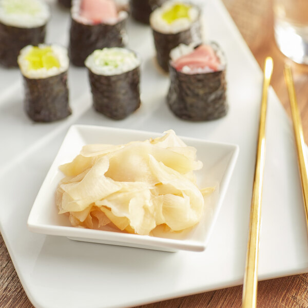 A plate of sushi rolls with Lucky Foods Pickled Sushi-Grade Ginger and chopsticks.