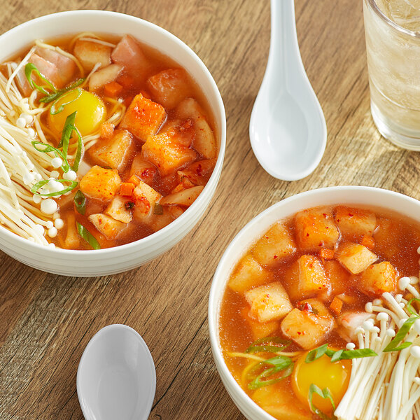 A bowl of Lucky Foods Radish Kimchi in soup with vegetables and mushrooms.