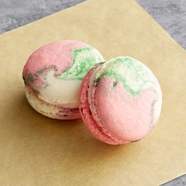 A close-up of a pink and green Macaron Centrale dragon fruit macarons.