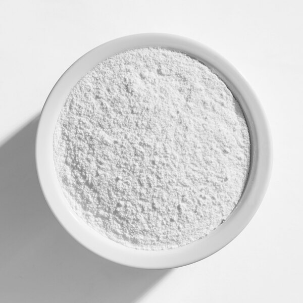 A white bowl filled with fine white popcorn seasoning powder.