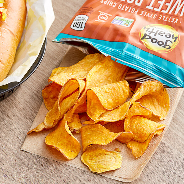 A bag of Good Health Sea Salted Sweet Potato Chips on a table next to a hot dog.