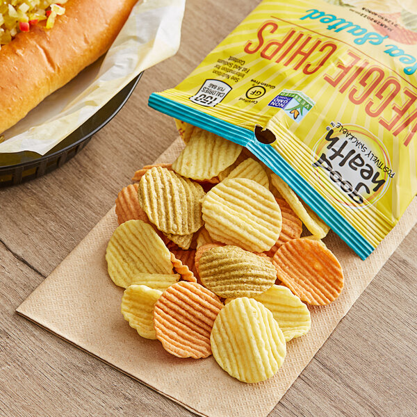 A hot dog and a bag of Good Health Sea Salted Veggie Chips on a table.