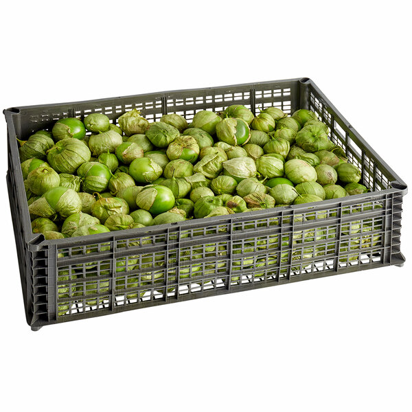 A metal basket filled with tomatillos on a table in an organic food store.